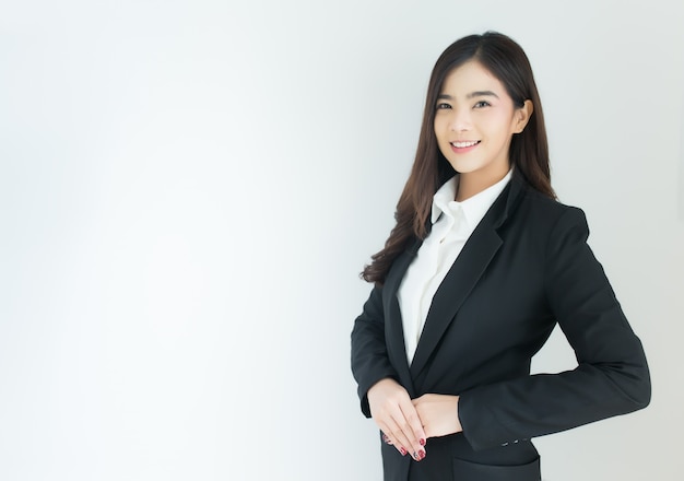 Portrait of young asian business woman welcoming gesture over white background.