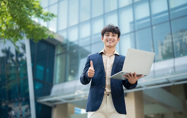 Portrait of young Asian businessman outside