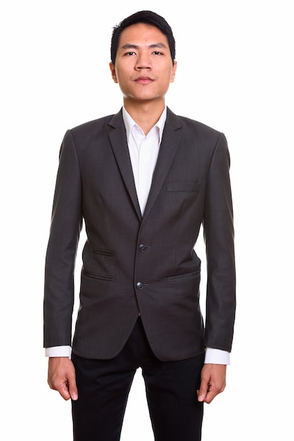 Portrait of young Asian businessman in suit standing