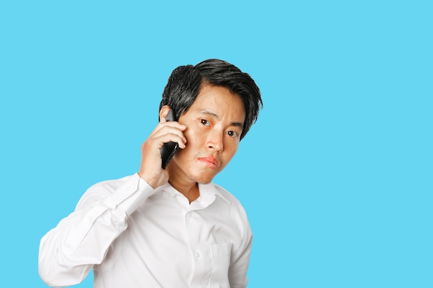 Портрет молодого азиатского бизнесмена разговаривает сотовый телефон изолирован
