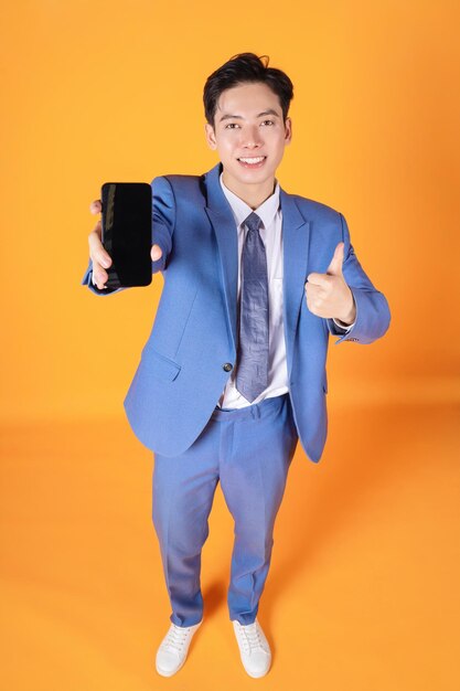 Portrait of young asian businessman using smartphone on background