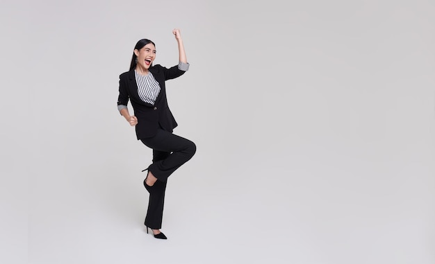 Portrait of young Asian businesswoman happy and success isolated on studio copy space