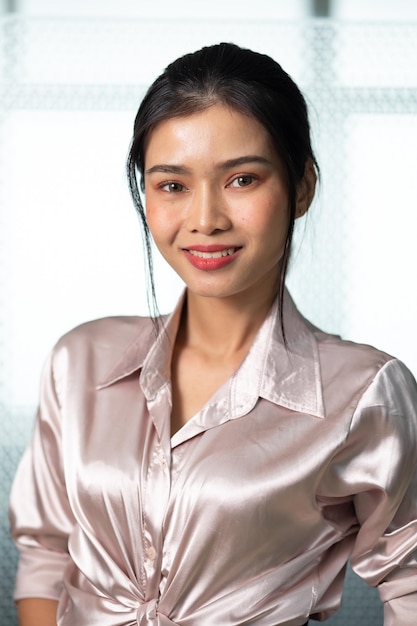 Portrait young asian businesswoman looking at the camera standing in modern office