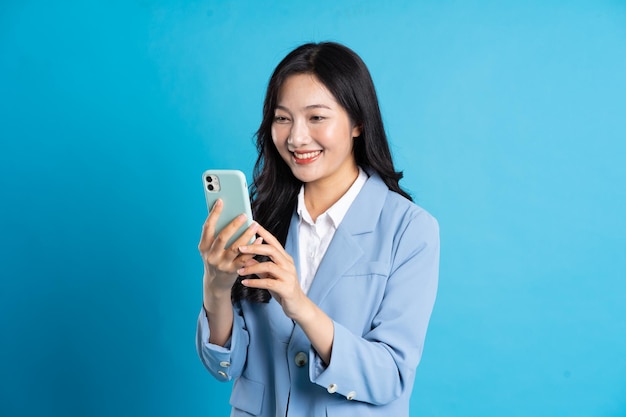 青の背景にポーズをとる若いアジアの実業家の肖像画