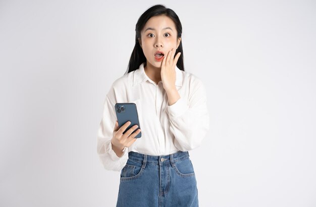 Portrait of young Asian businesswoman using phone on white background