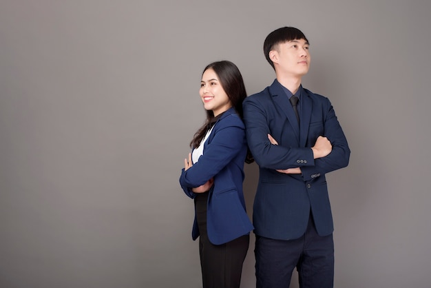 Ritratto di giovani uomini d'affari asiatici fiducia su sfondo grigio