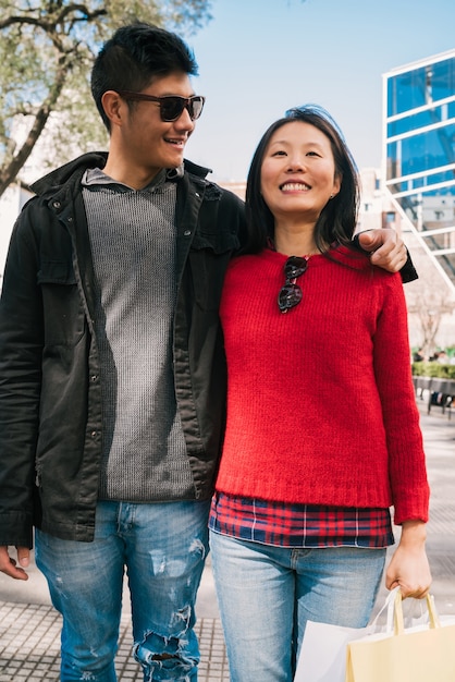 Photo portrait of young asian couple in love walking in the city after shopping. shop concept.