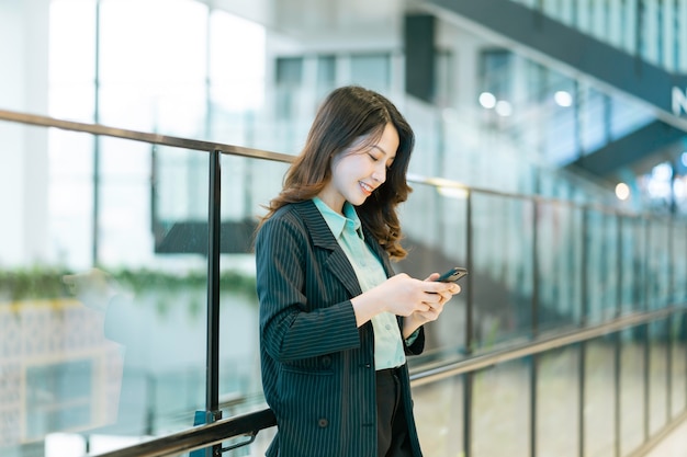 Portrait of a young Asian female director holding a phone