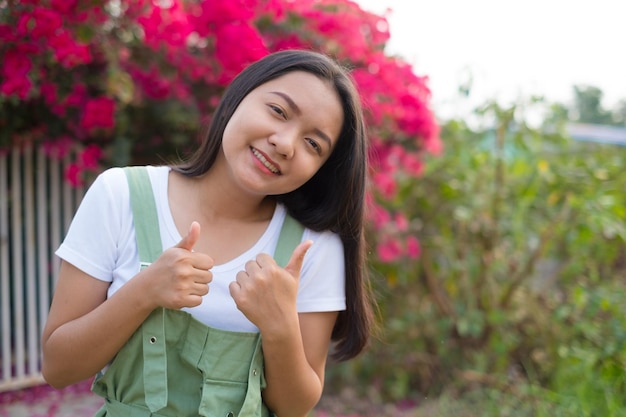 Portrait Young Asian girl outdoor beautiful flower background