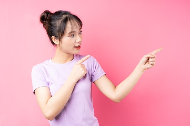 Portrait of young asian girl on pink background