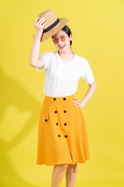 Portrait of young Asian girl on yellow background