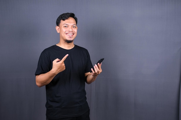 portrait of young asian guy in a batik posing isolated on gray background