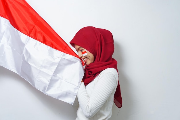 Portrait of young asian kissing red and white flag of indonesia independence day