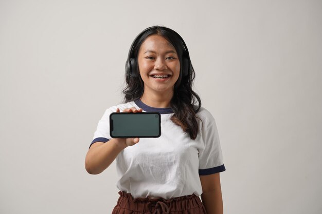 Portrait of young asian lady using mobile phone with cheerful expression, show something on phone