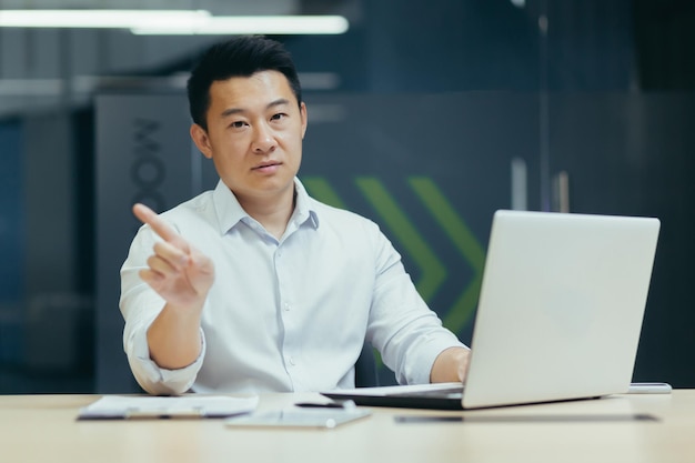 Portrait of a young asian man confused shows with his hands that it is not allowed did not