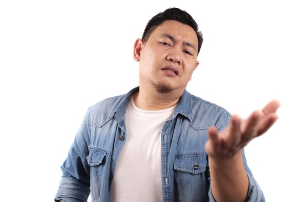 Photo portrait of young asian man feels disappointed upset and argue looking at camera denial gesture