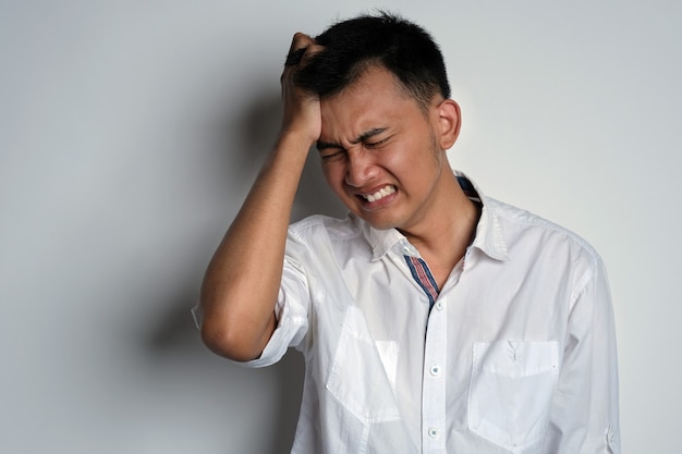 Ritratto di giovane uomo asiatico che ha un forte mal di testa