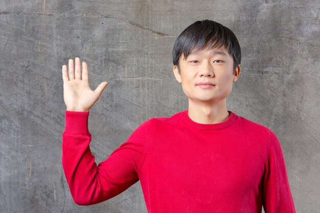 Portrait of young asian man pointing 