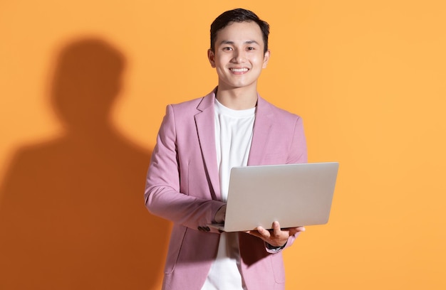 Portrait of young Asian man posing on background