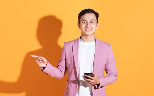 Portrait of young Asian man posing on background