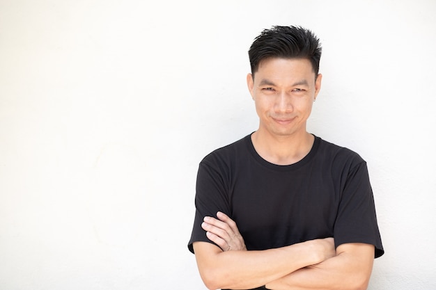 Portrait of young asian man standing on white wall background