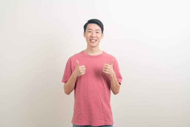 portrait young Asian man thumbs up or ok hand sign on white background