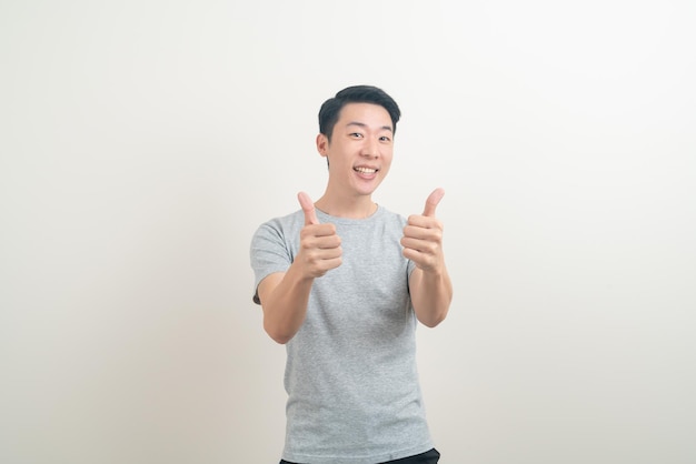 portrait young Asian man thumbs up or ok hand sign on white background