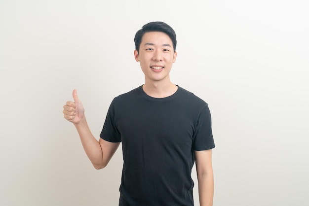 portrait young Asian man thumbs up or ok hand sign on white background