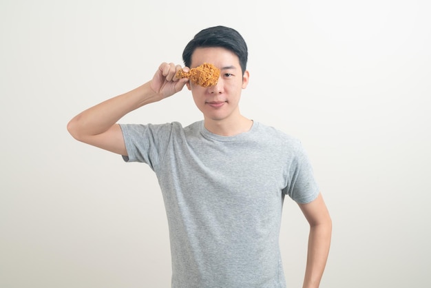 portrait young Asian man with fried chicken on hand