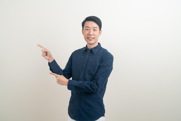 portrait young Asian man with hand pointing or presenting on white background