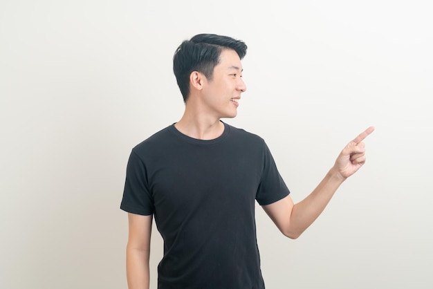 Ritratto giovane uomo asiatico con la mano che punta o presenta su sfondo bianco