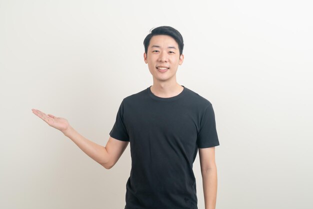 portrait young Asian man with hand pointing or presenting on white background