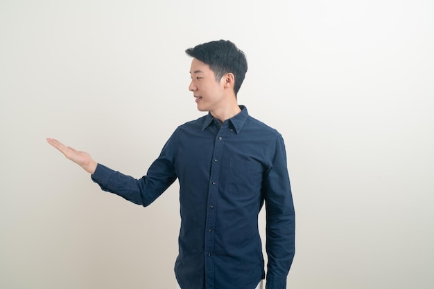 Portrait young Asian man with hand pointing or presenting on white background