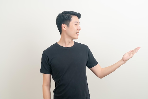 portrait young Asian man with hand pointing or presenting on white background