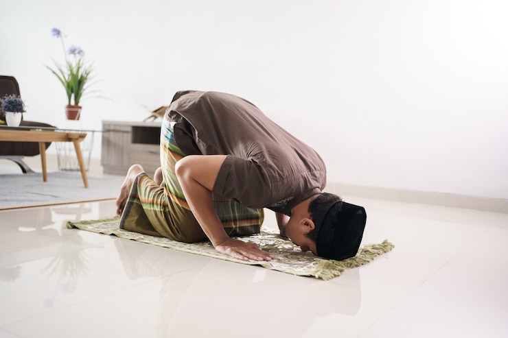 Photo portrait of young asian muslim man praying at home