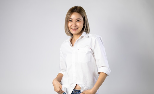 Portrait of Young Asian pretty cute cheerful woman wearing braces and looking at camera on white background. natural make-up, and white teeth