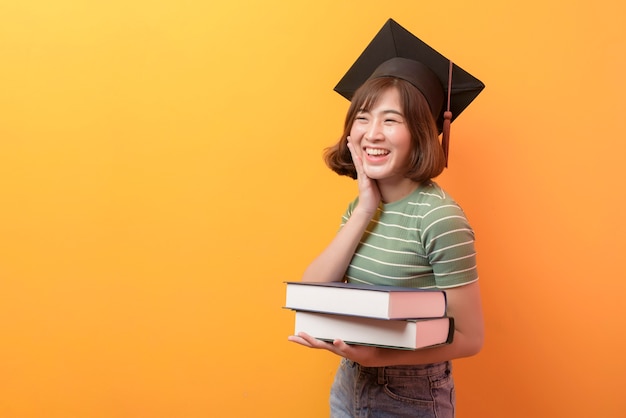 A portrait of young Asian student wearing graduation cap.