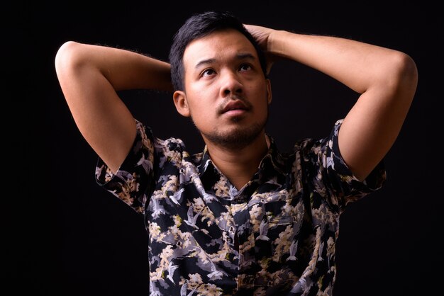 portrait of young Asian tourist man with bohemian shirt on black