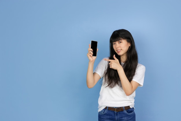 Portrait of young asian woman isolated on blue