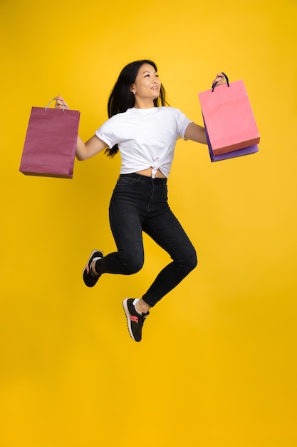 Portrait of young asian woman isolated on yellow studio background