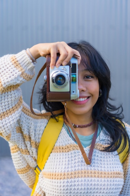 Photo portrait of a young asian woman photographing with a vintage photo camera vacation concept tourist woman