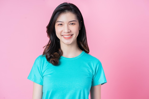 Portrait of young Asian woman on pink background