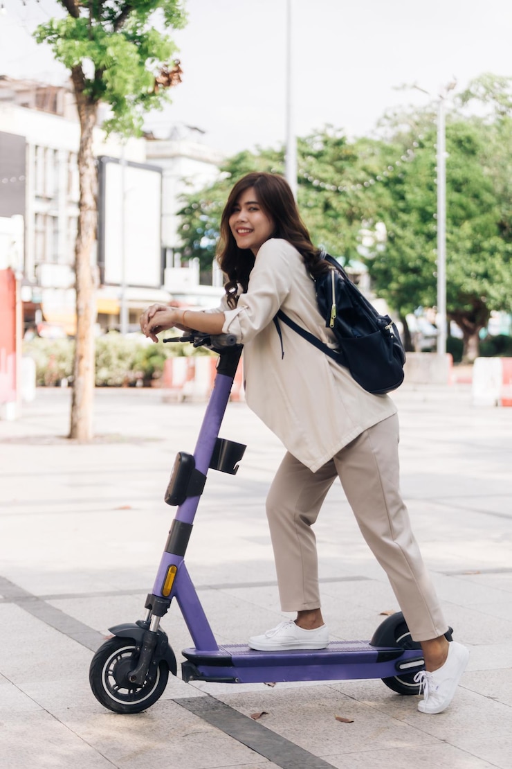 Photo portrait of young asian woman riding electric scooter in park
