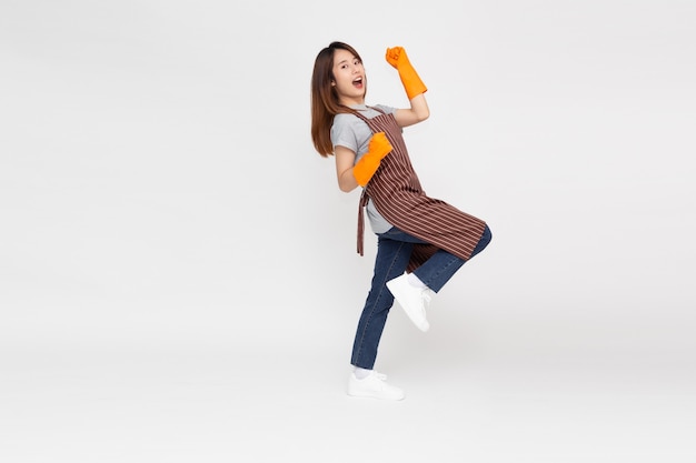 Portrait of young Asian woman standing and wearing orange rubber gloves for hands protection