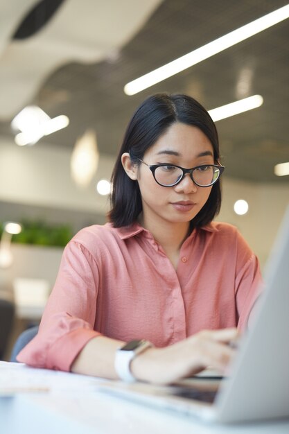 Photo portrait of young asian woman using laptop while studying in cafe