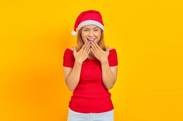 Portrait of young asian woman wearing christmas hat with surprised facial expression