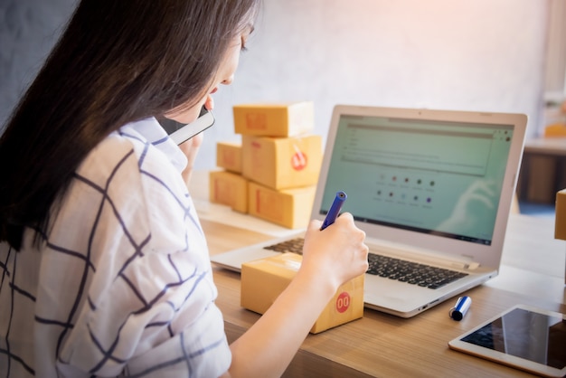 Foto ritratto di giovane acquisto online di lavoro asiatico con il computer portatile a casa