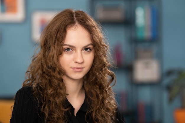 Portrait of young attractive brunette teenage girl with curly hair