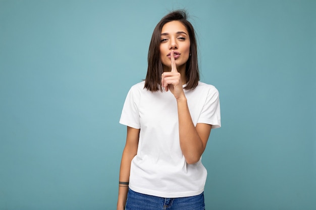 Portrait of young attractive brunette woman with sincere emotions wearing casual white tshirt for