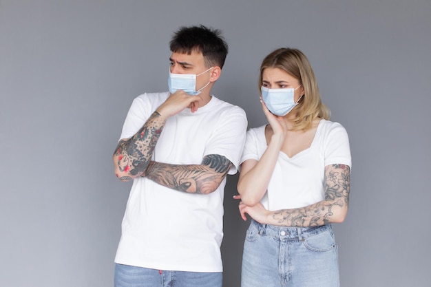 Portrait of young attractive family couple with surgical medical mask standing together